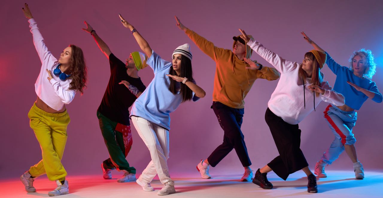 Grupo de jóvenes bailando Popping en formación coreográfica.