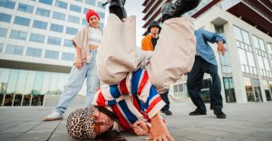 Dos bailarines de Breaking haciendo acrobacias en una batalla callejera.