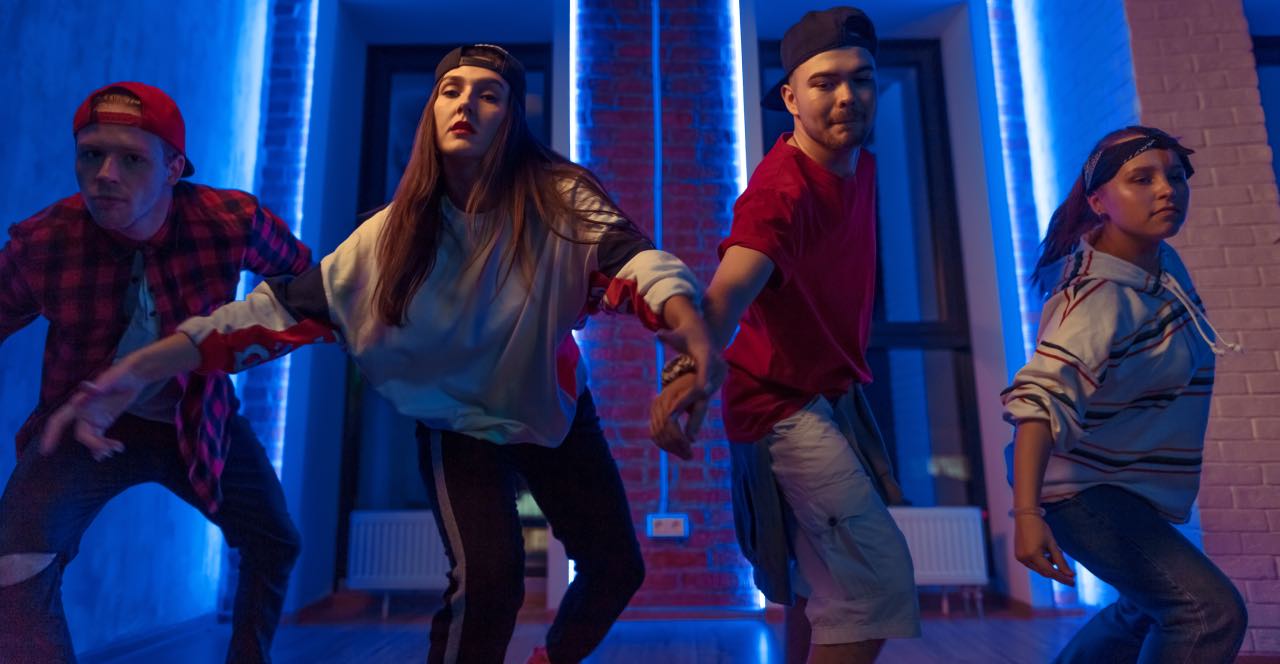 Grupo de chicos y chicas bailando House en el interior de un edificio.