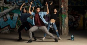 Una chica y dos chicos bailando Krumping con fuerza en la azotea de un edificio.