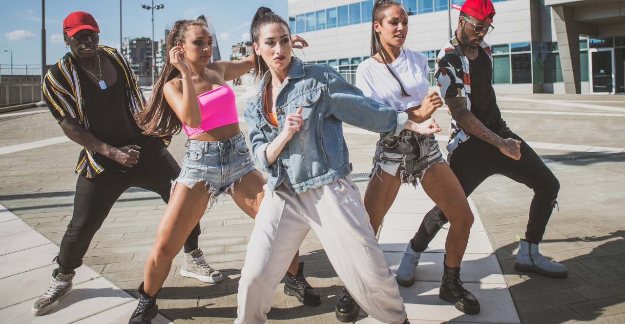 Dos chicos y tres chicas en una pose poderosa de Krumping en la calle.