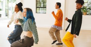 Cuatro jóvenes aprendiendo Locking en una clase de danza.